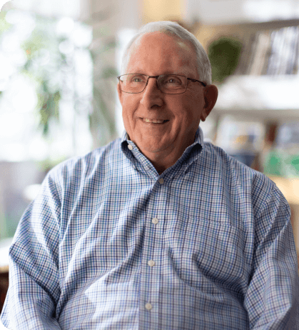 Picture of Frank, a real patient who appears to be in his mid 70's with white hair and glasses, smiling.