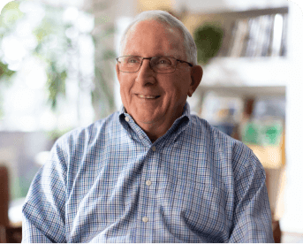 Picture of Frank, a real patient who appears to be in his mid 70's with white hair and glasses, smiling.
